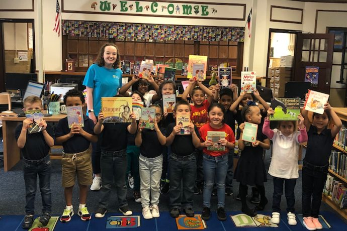 Photo of Fort Worth elementary school students receiving books from a book drive.