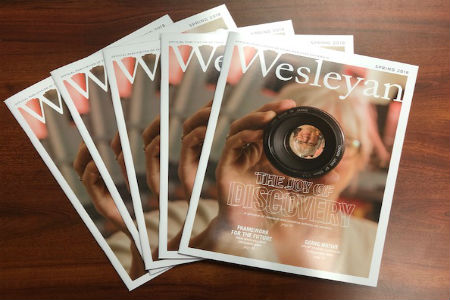 Set of Wesleyan magazine issues spread out on a desk