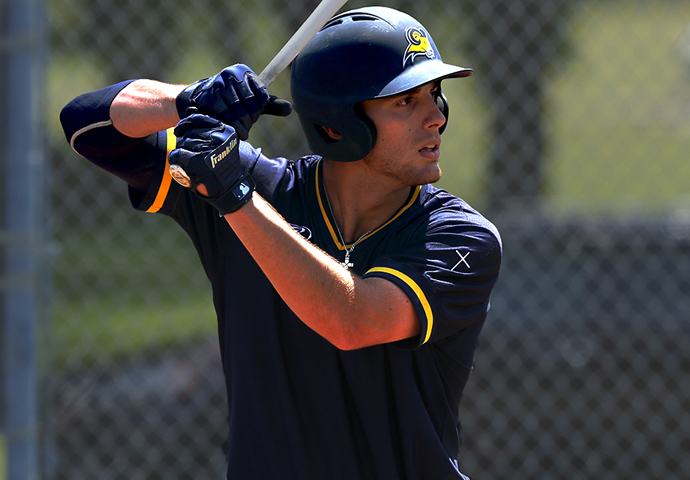 Kiki Menedez is at bat at a recent baseball game wearing the navy blue uniforms and helmet.