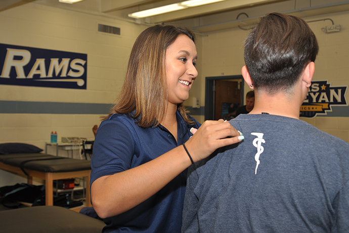 Breanne Zuniga helps a student in the Texas Wesleyan athletic training room.