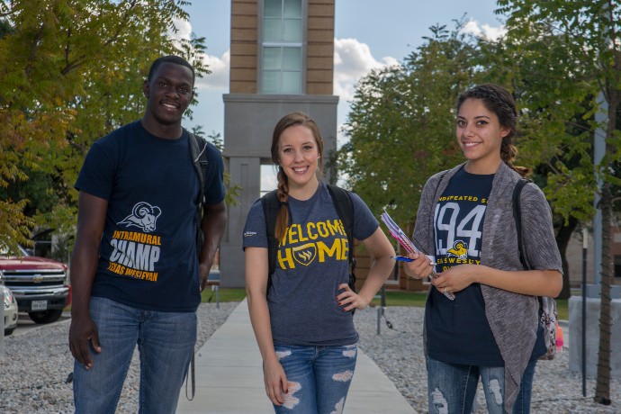 Photo of students smiling in front of the Canafax clocktower.