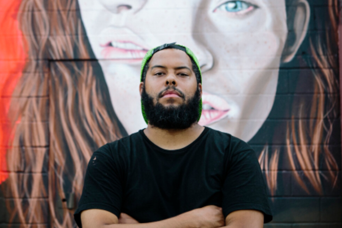 Photo of artist Jeremy Biggers, previewing his art exhibition on campus.