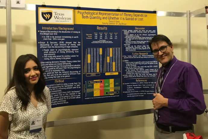 Photo of Texas Wesleyan psychology student Maria Perez and Jay Brown, professor of psychology with Maria's presentation at Undergraduate Research Day in Austin.