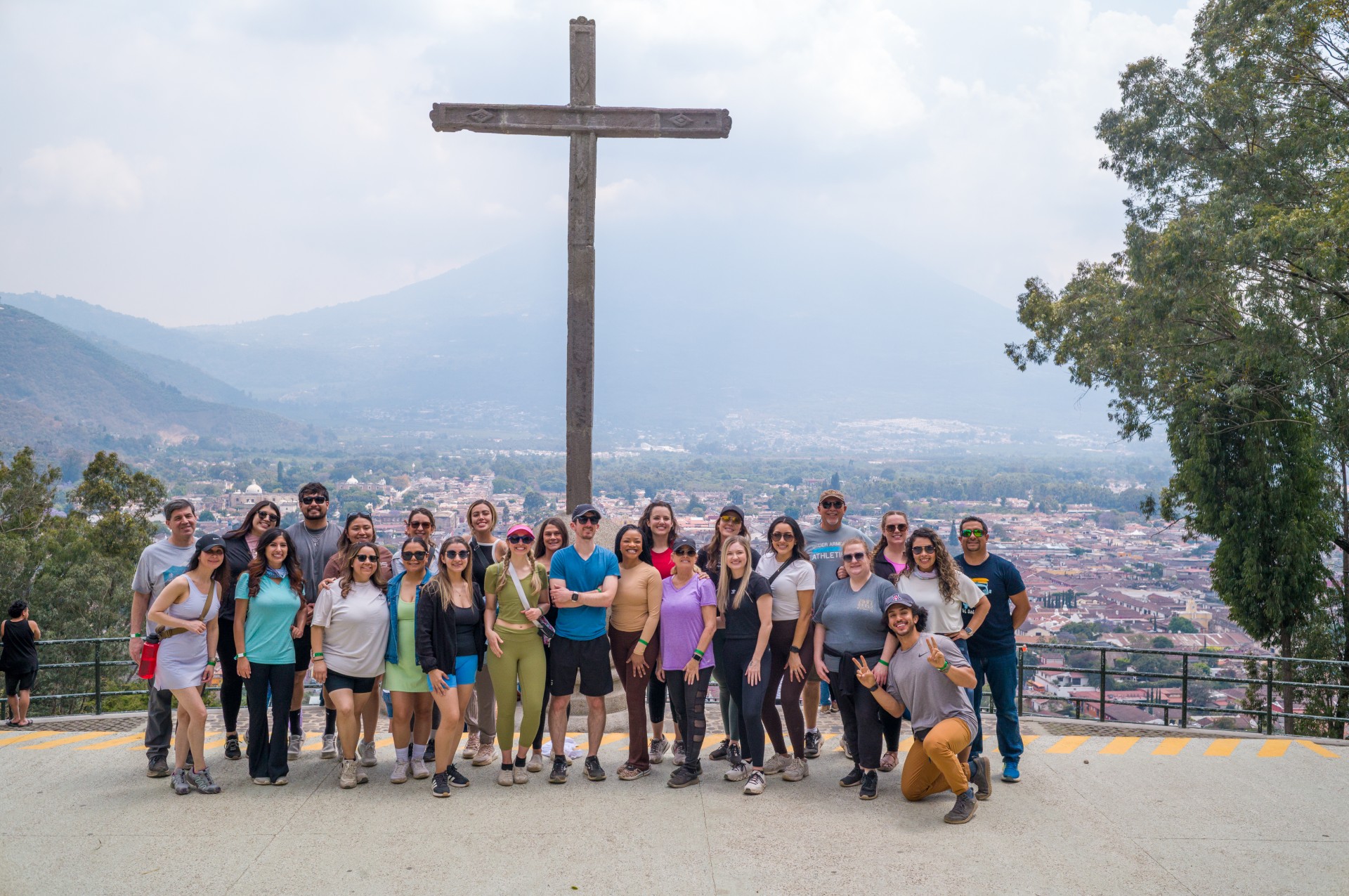 Students on a mission trip in front of a cross