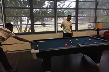 Students play pool on the new table in Stella Hall.