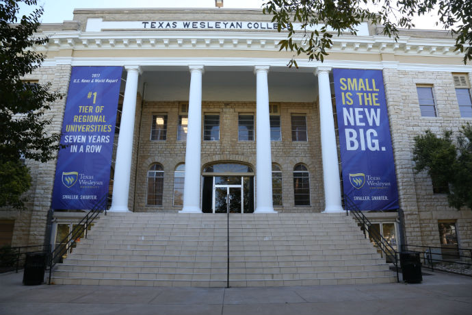 Outside view of Oneal-Sells Administration building at Texas Wesleyan. Displayed on the building are banners saying 