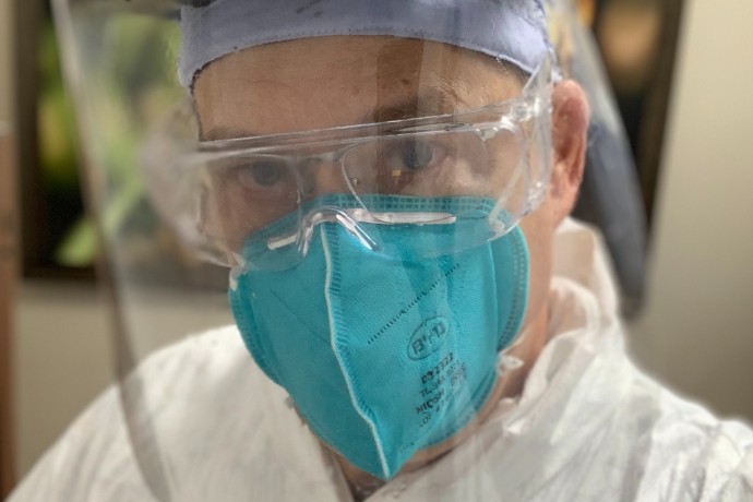 Dr. Victor Test dressed in face mask and shield