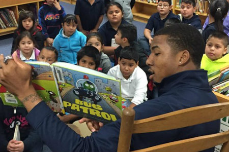 Texas Wesleyan basketball player reading to kids