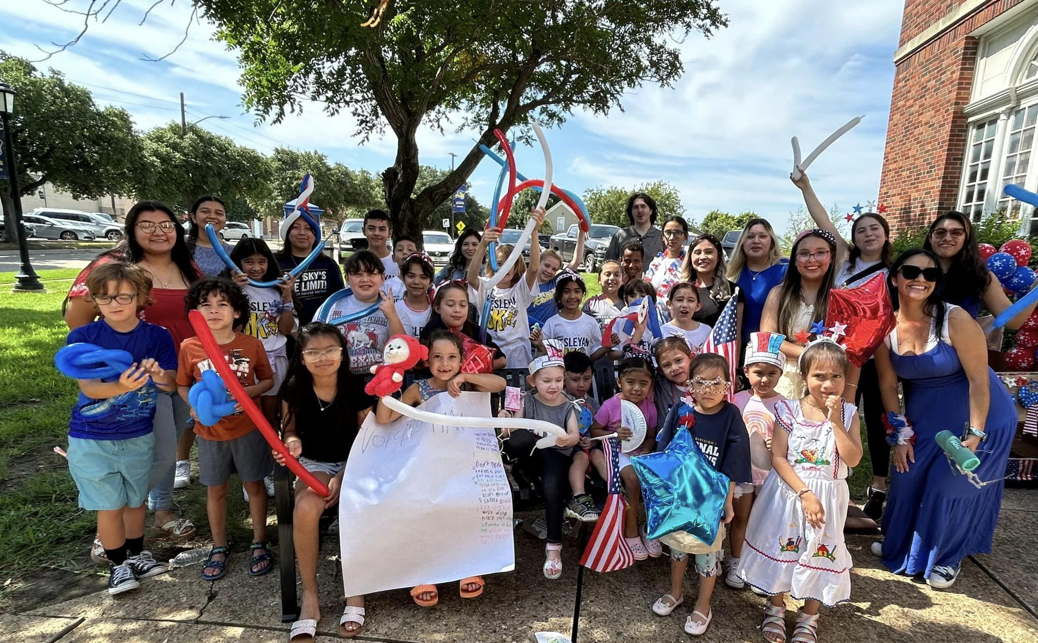 TXWES Education Students pose with elementary students in fourth of July parade