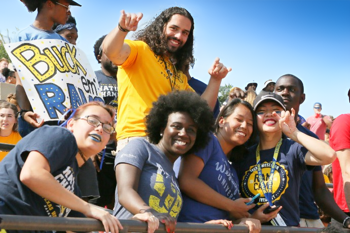 Student group smiling as the cheer on the rams at a game