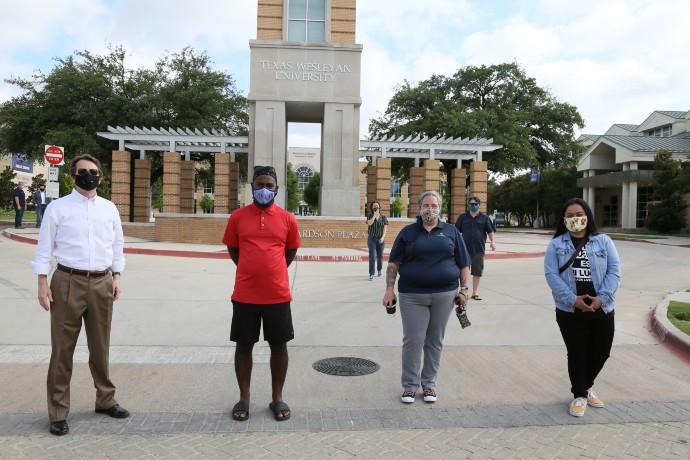 Photo of University President Fred Slabach with staff and students in front of Canafax Clocktower during a Juneteenth event.