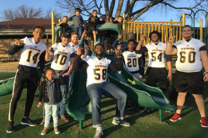 Photo of Texas Wesleyan football players taking part in a community service project with students at Temple Christian School in Fort Worth.