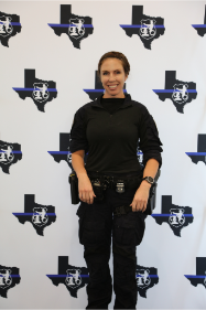 Women of Law Enforcement Speaker, Officer Hannah Rivard, standing in front of the WoLE backdrop