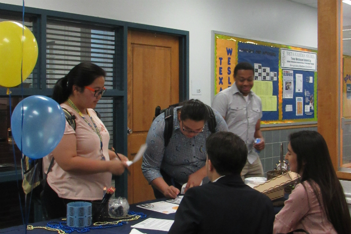 Photo of Finance Club students manning the table during the School of Business Open House event.