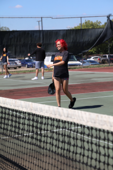 A female student smiling playing pickleball