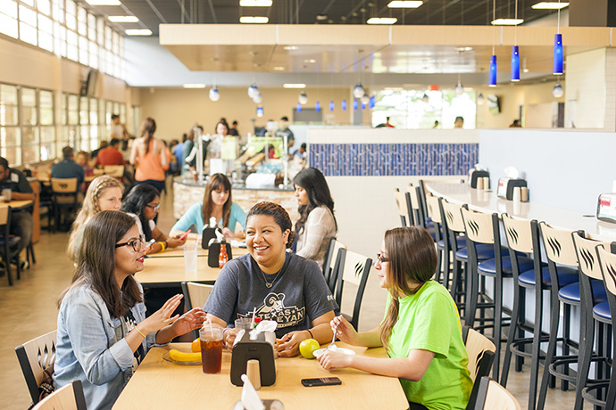 Photo of students sitting together and sharing a meal at Dora's Dining Hall.