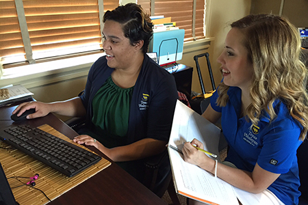 Melondy Doddy (left), admissions counselor and community outreach coordinator, reviews a monthly progress report with Nicole Gillihan, G-Force mentor and junior education major. 
