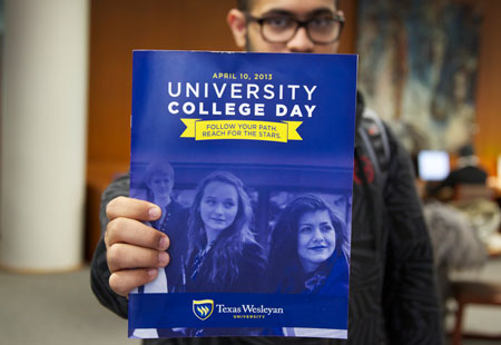 Texas Wesleyan male student holding a University College Day magazine